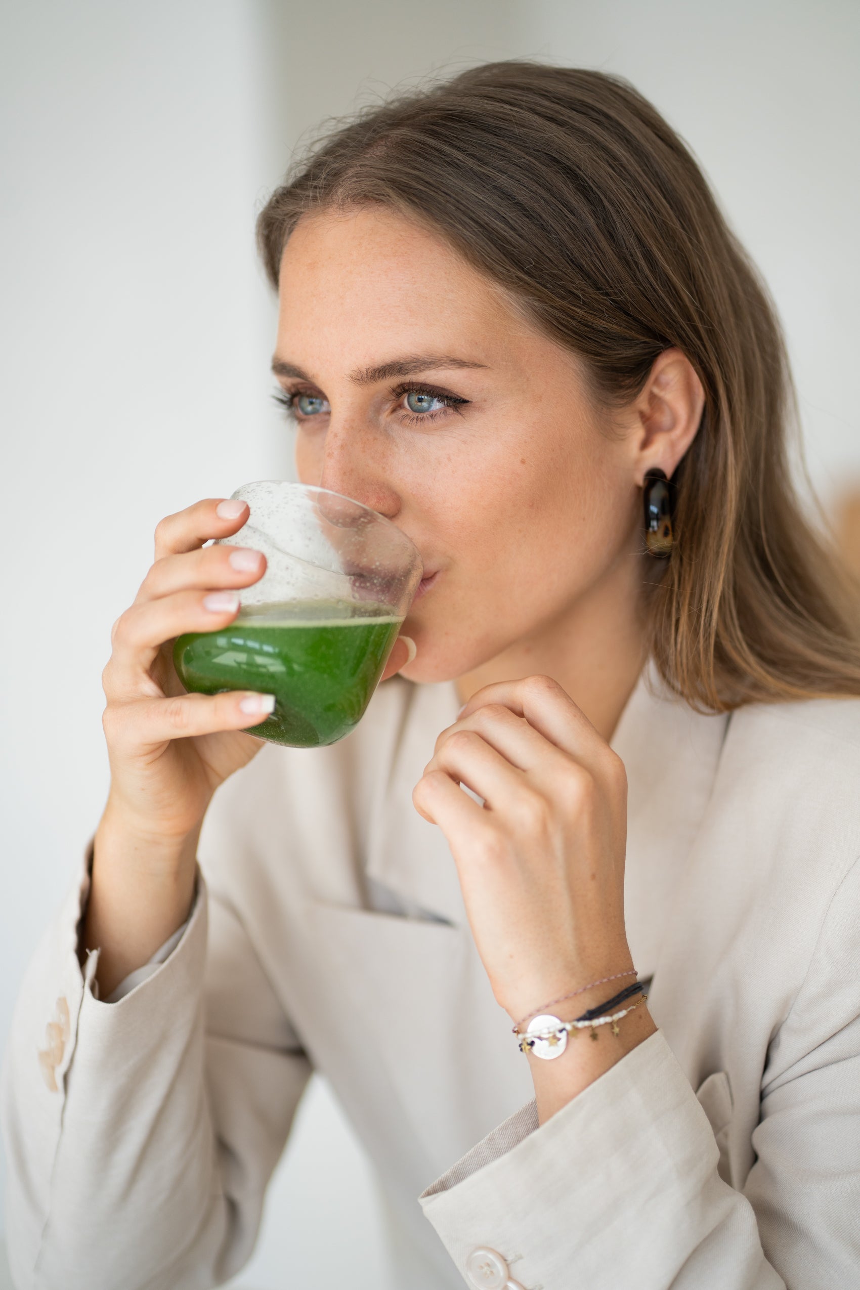 vrouw met licht haar en lichte ogen drinkt een matcha thee