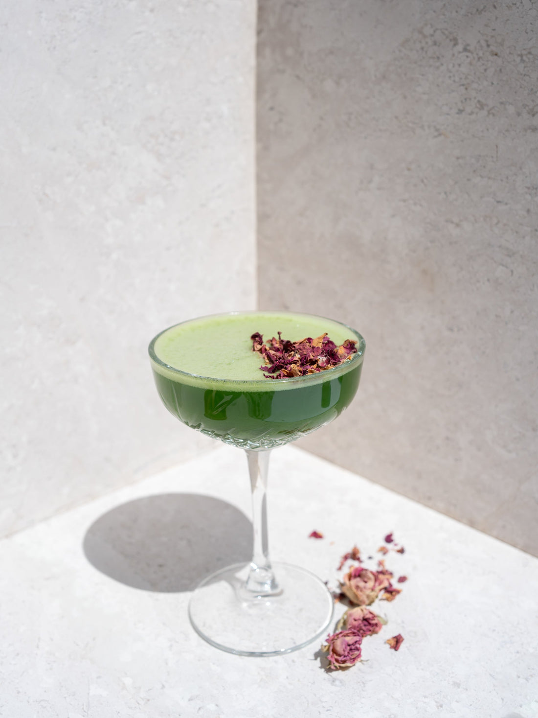 Iced matcha in een cocktail glas met gedroogde bloemen