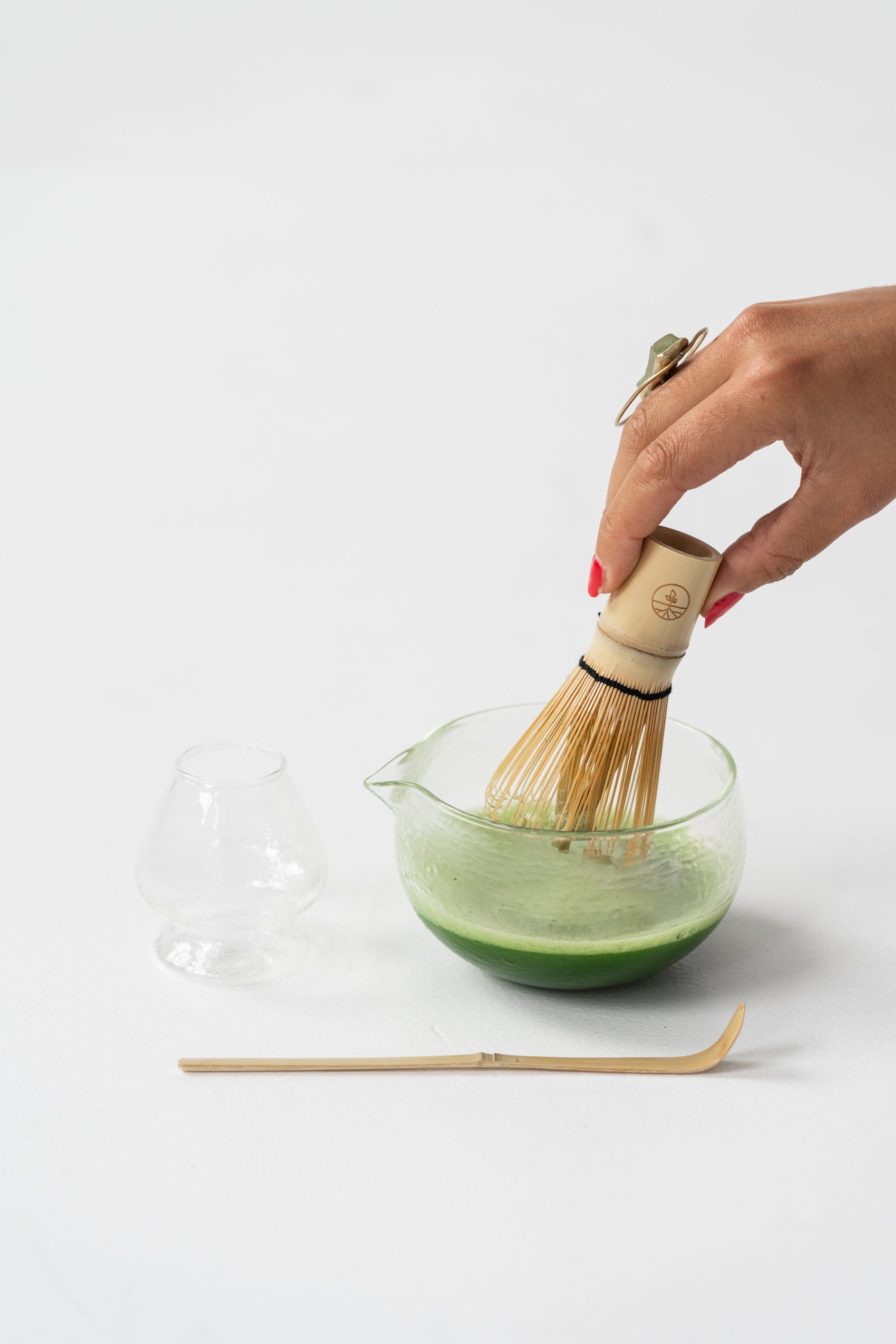 22.Matcha wat geklopt wordt in de matcha bowl met een hand die de whisk vasthoudt.