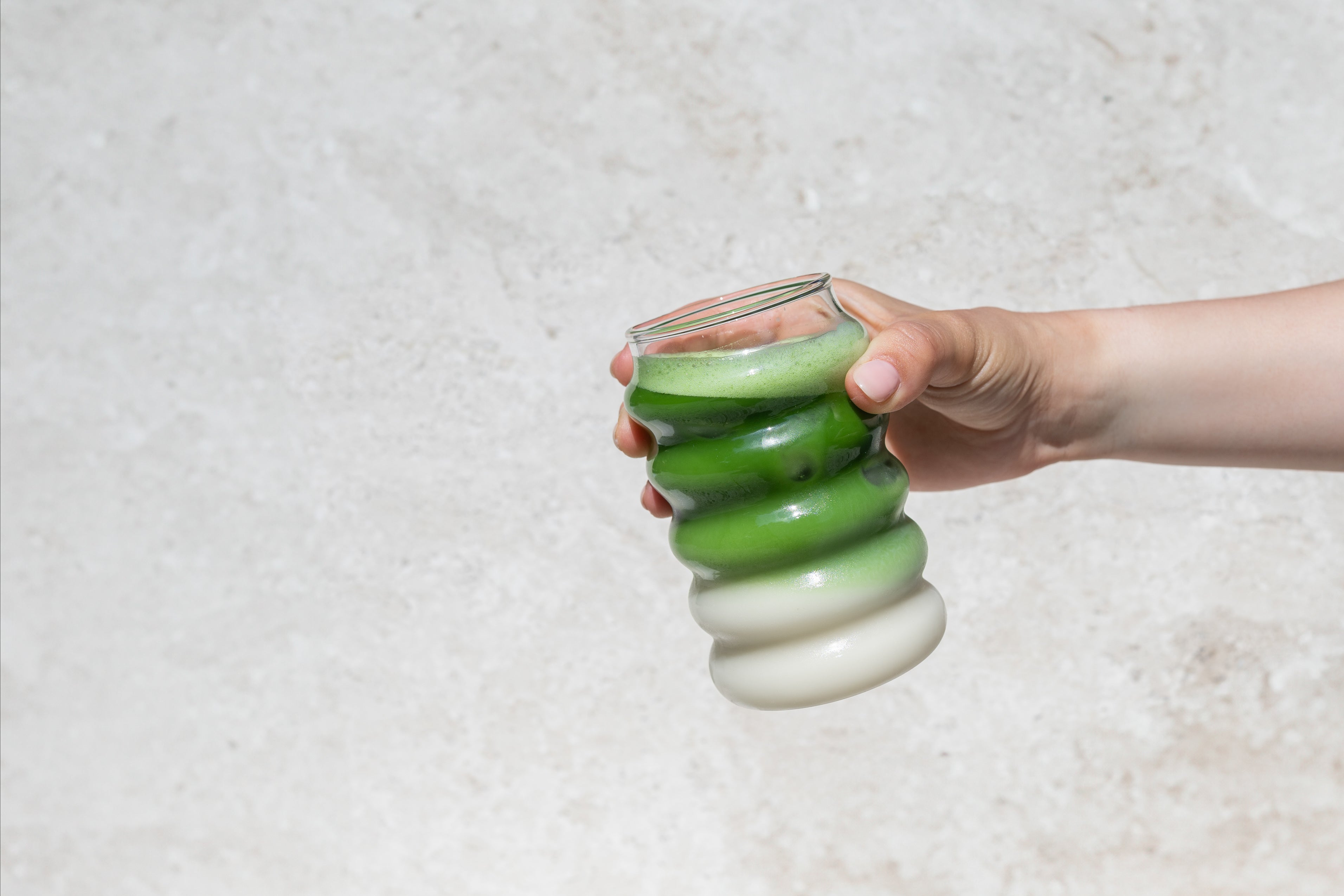 vrouw houdt een matcha latte aan 