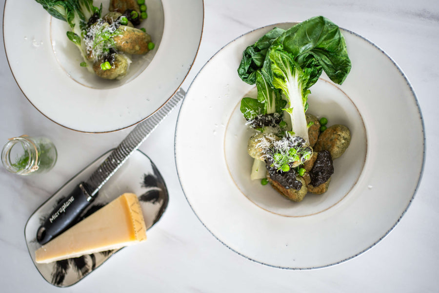 Groene matcha gnocchi met miso-botersaus, paksoi en doperwten op een bord