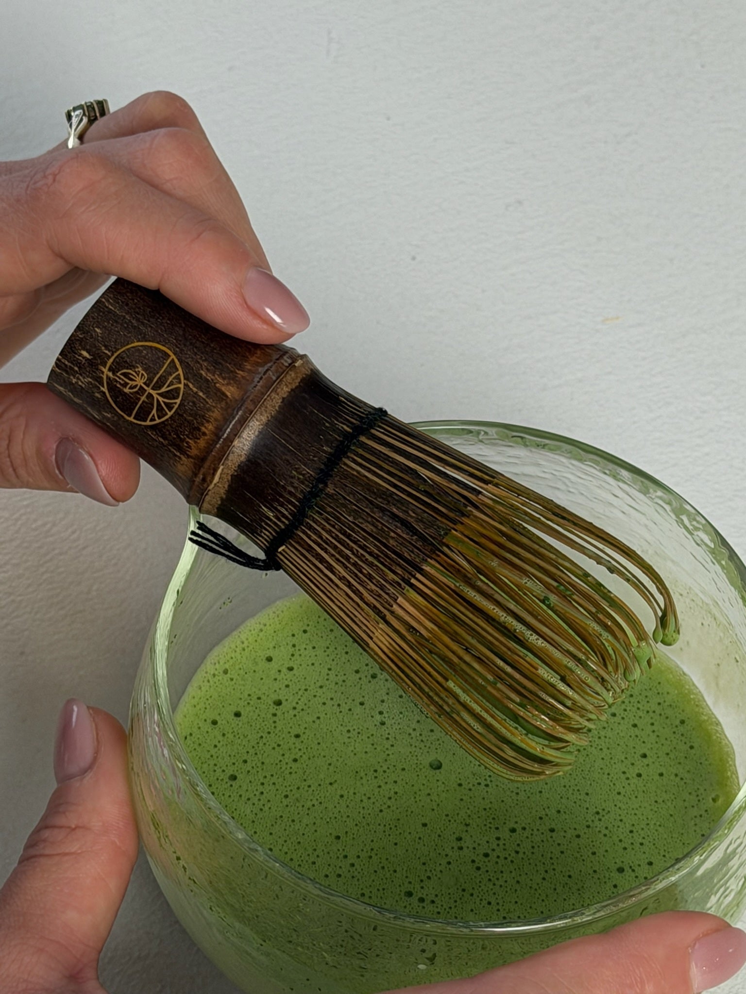 Chasen in hand met geklopte matcha thee